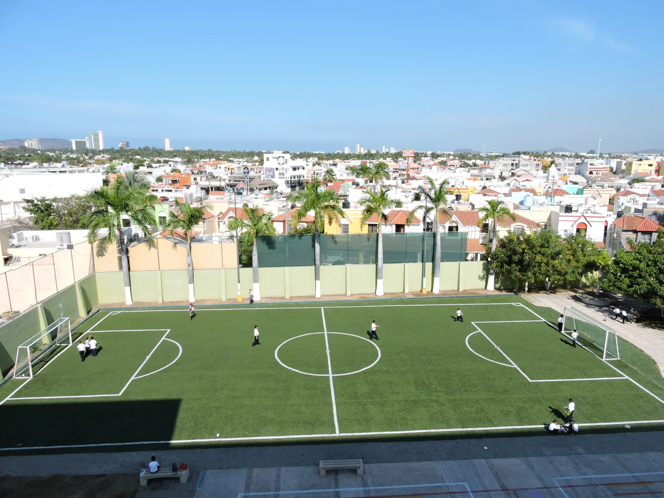 Cancha de fútbol del colegio con la ciudad al fondo